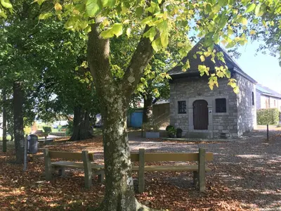 two benches in front of a building with a tree at Hotel-Restaurant Zum Onkel Jonathan in Raeren