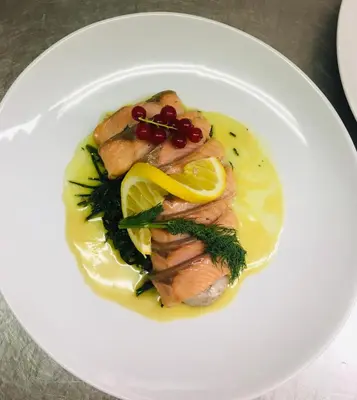 a white plate of food with fish and vegetables at Hotel-Restaurant Zum Onkel Jonathan in Raeren