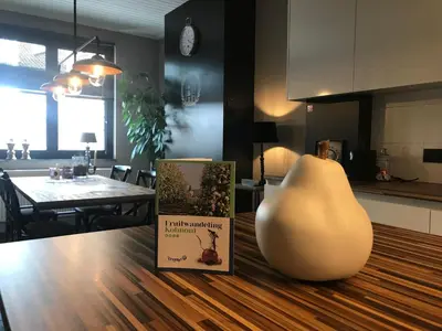 a book sitting on top of a table with a vase at Le petit béguinage in Tongeren