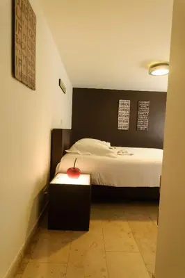 a bedroom with a bed with a black wall at Hotel Pracha in Borgloon