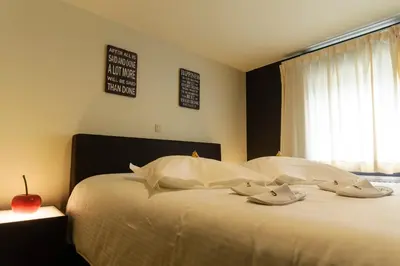 a bedroom with a bed with pillows and an apple on it at Hotel Pracha in Borgloon