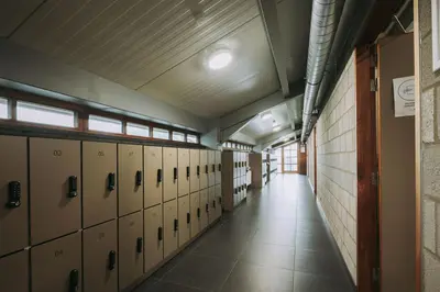 a long hallway with lockers in a building at Kamphuis Heideven in Peer