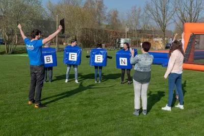 a group of people standing in a field with their hands up at Kamphuis Heideven in Peer