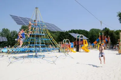 a group of people playing on a playground on the beach at Vakantiepark Wilhelm Tell Superieur Chalet in Oudsbergen