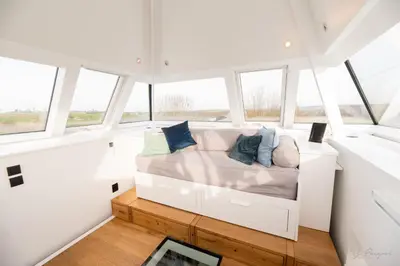a room with a couch in the middle of windows at Logement insolite La tour de Larbuisson in Herve