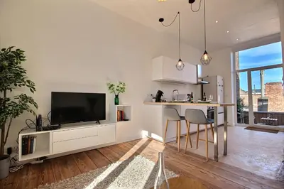 a kitchen with a flat screen tv and a counter at Tokyo's Place in Liège