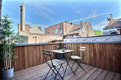 a patio with a table and chairs on a balcony at Tokyo's Place in Liège