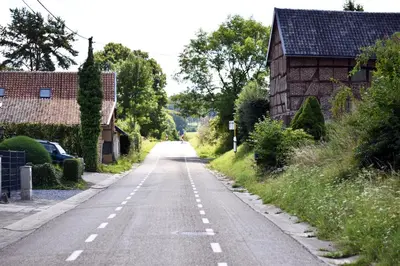 an empty road in a village with a barn at Vakantiewoning Veurservallei in Voeren