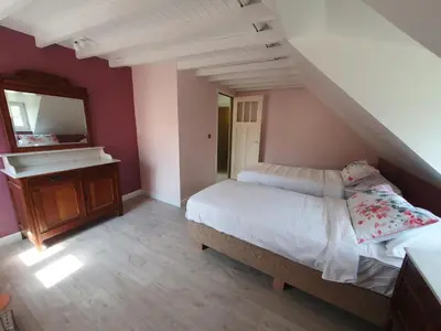 a bedroom with a bed and a vanity and a mirror at Haspengouws Hoeveke in Borgloon