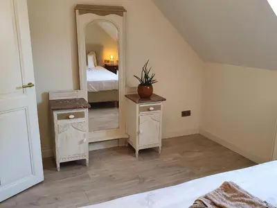 a bedroom with a large mirror and a bed at Haspengouws Hoeveke in Borgloon