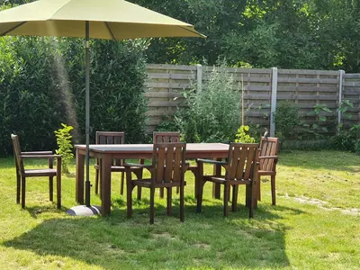 a table and chairs with an umbrella in a yard at Haspengouws Hoeveke in Borgloon