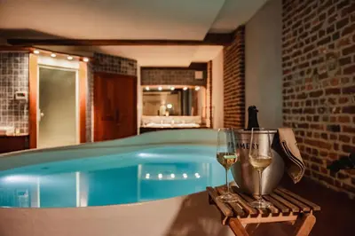 a swimming pool with a glass of wine and a glass of wine at Baiser de Cupidon in Verviers