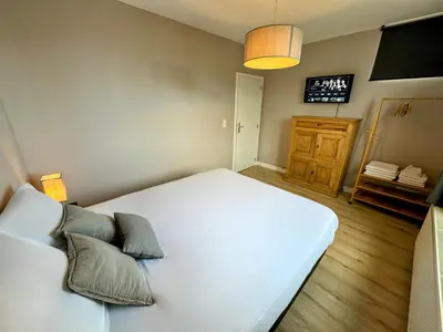 a bedroom with a white bed and a tv at Le Boisseliège in Liège