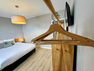 a bedroom with a bed and a flat screen tv at Le Boisseliège in Liège