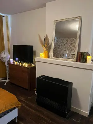 a living room with a television and a mirror at In The Air cosy room (Cœur Historique de Liège) in Liège