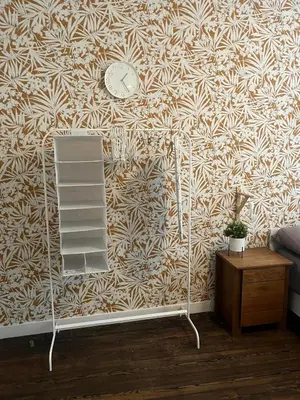 a room with a clock on a wall with a shelf at In The Air cosy room (Cœur Historique de Liège) in Liège