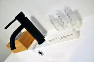 a white sink with a black stand with boxes on it at Spelver95 in Bilzen