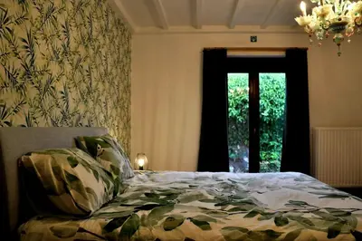 a bedroom with a bed and a window and a chandelier at Spelver95 in Bilzen