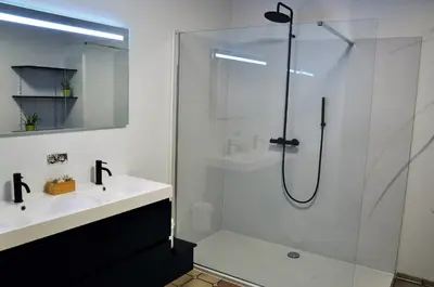 a bathroom with a shower and a white sink at Spelver95 in Bilzen