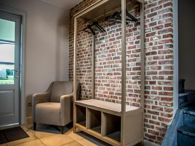 a room with a chair and a brick wall at Peaceful Peer Holiday Home in Peer