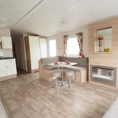 a living room with a table and a fireplace at Camping De Binnenvaart Superior Chalet in Houthalen-Helchteren