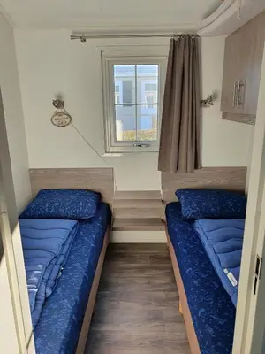 two beds in a small room with a window at Chalet 11 - Bergzicht Teuven in Teuven