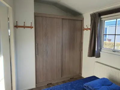 a bedroom with a wooden cabinet and a bed at Chalet 11 - Bergzicht Teuven in Teuven
