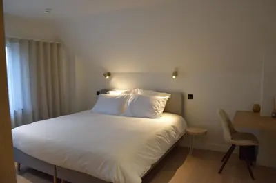 a bed with white sheets and pillows in a room at B&B Villa Mimosa in Pelt