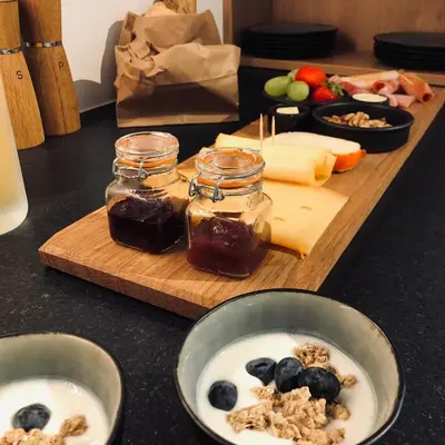 a table with a cutting board with jam and blueberries at B&B Villa Mimosa in Pelt