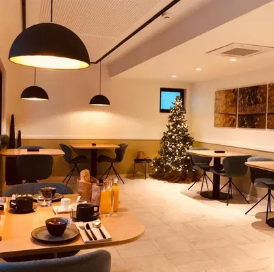 a dining room with a christmas tree in the background at B&B Villa Mimosa in Pelt
