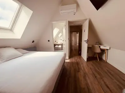 a bedroom with a large white bed and a desk at B&B Villa Mimosa in Pelt