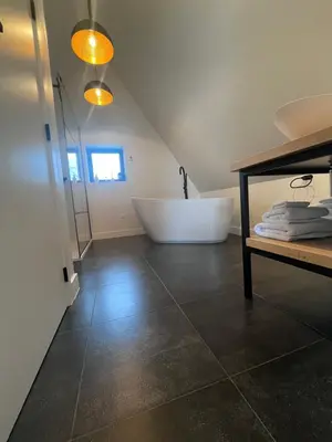 a bathroom with a bath tub and a sink at B&B Villa Mimosa in Pelt