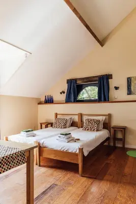 a bedroom with two beds and a window at De Zwarte Stok in Riemst
