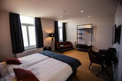 a bedroom with a bed and a desk and a chair at Burgemeesterhuys in Beringen