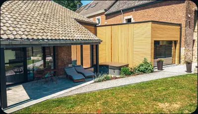 a house with a patio with a table and chairs at Les gîtes de Bouxhmont in Herve
