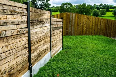 a wooden fence in a yard with green grass at Les gîtes de Bouxhmont in Herve