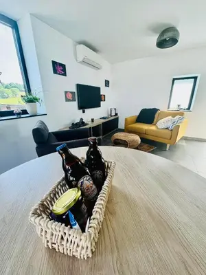 a basket of bottles on a table in a living room at Les gîtes de Bouxhmont in Herve