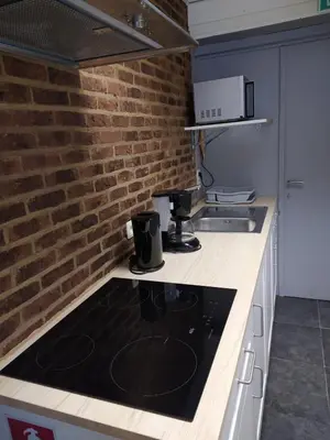 a kitchen with a stove and a brick wall at The Place in Lommel