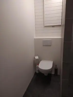 a small bathroom with a white toilet and a window at The Place in Lommel