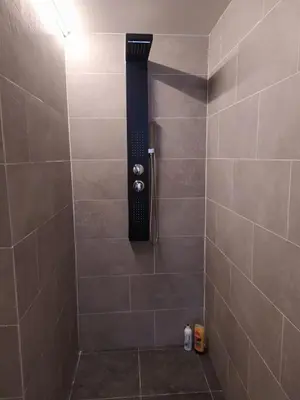 a shower with a black shower head in a bathroom at The Place in Lommel