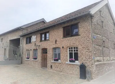 a brick building with windows and a door at Het Stalhuys in Riemst