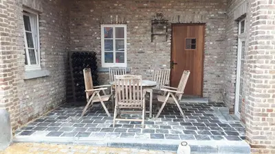 a table and chairs sitting on a brick patio at Het Stalhuys in Riemst