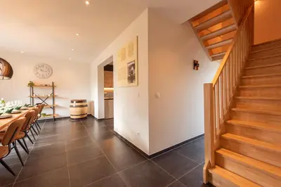 a dining room with a table and a staircase at NEW - De sheeper - 10Personen - 5slaapkamers - Sauna - Jacuzzi in Riemst