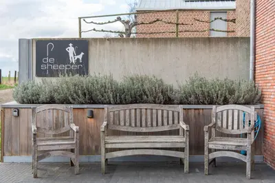 two wooden chairs sitting next to a fence at NEW - De sheeper - 10Personen - 5slaapkamers - Sauna - Jacuzzi in Riemst