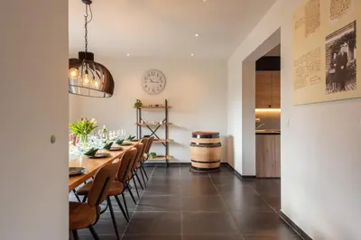 a dining room with a long table and chairs at NEW - De sheeper - 10Personen - 5slaapkamers - Sauna - Jacuzzi in Riemst
