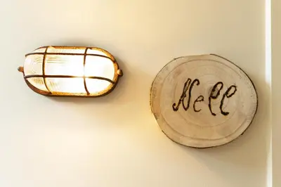 a light on a wall with the word help written on a log at B & B De Romeinse Katzei in Borgloon