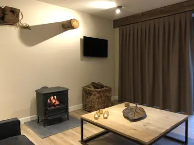 a living room with a table and a fireplace at B & B De Romeinse Katzei in Borgloon