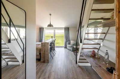 a room with stairs and a dining room with a table at Bed en Vrijheid in Peer