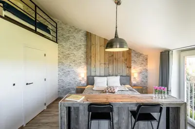 a room with a bed and a table with chairs at Bed en Vrijheid in Peer