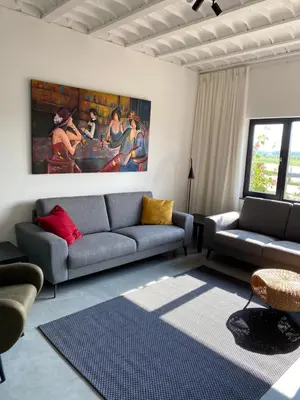 a living room with a couch and a painting on the wall at Maashuys in Lanaken